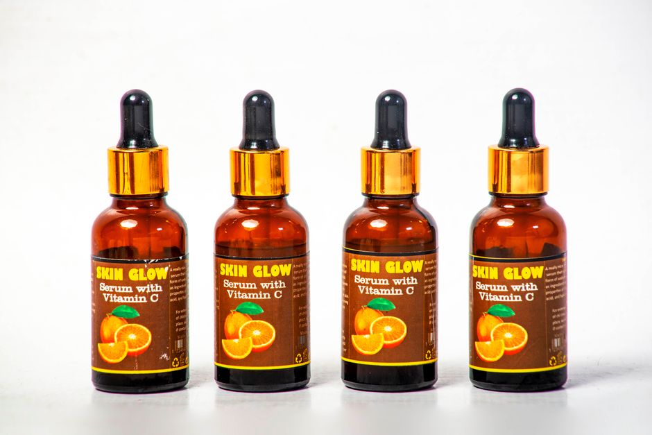 Four Vitamin C serum bottles arranged on a white background for skincare.